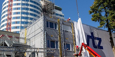 Installation des Großbanners am Westdeutschen Tumorzentrum des UKM