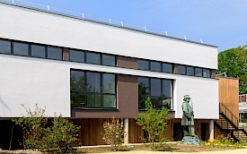 Das Konferenz- und Schulungszentrum teilt sich in zwei Gebäudeteile auf: Hier mit weißem Anstrich und braunen Akzenten im Fensterbereich …