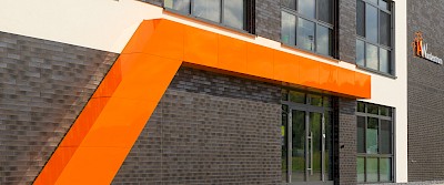 Unübersehbar: Die 13 Meter lange Portalblende in aufmerksamkeitsstarkem Orange.