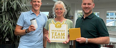 Heiko Tigges (links) und Tim Drüner überraschten Bettina Lefert zusammen mit weiteren Brückingern in der Kantine.